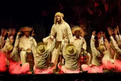 Bad Bunny durante uma apresentação, rodeado de bailarinos vestidos como camponeses porto-riquenhos