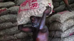 A labourer carries a sack of onions at a market in Colombo on March 20, 2023