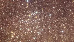 صورة تبدو كأنها بريق ذهبي ووميض أبيض لمئات النقاط المضيئة، لكنها في الواقع صورة لعنقود نجمي مفتوح