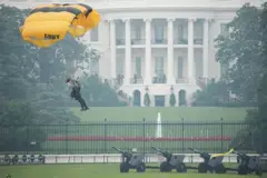 Un miembro del Equipo de Paracaidistas del Ejército de EE. UU., también conocido como los Caballeros Dorados, se lanza en paracaídas cerca de la Casa Blanca.