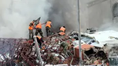 इसी साल अप्रैल में सीरिया के दमिश्क में हुए हवाई हमले से प्रभावित जगह पर रेस्क्यू वर्कर्स