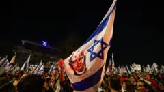 Una bandera israelí con la imagen de Netanyahu y una mancha roja sobre su cara