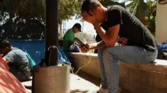 مهاجر يستخدم الهاتف المحمول