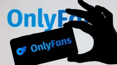 Uma mão segurando um celular com o logo do OnlyFans.