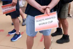 Personas con carteles de que necesitan entradas