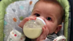 बोतल से दूध पीता एक बच्चा