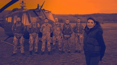 Женщина рядом с военными на фоне вертолета