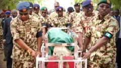 Military officers carry body of slain soja