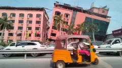 Motoristas passam por um prédio danificado após um forte terremoto atingir o centro de Mianmar, em Mandalay