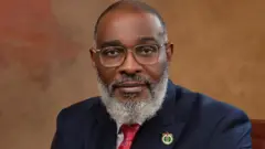 A man wit white beard and blue suit