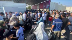 Una fila de ambulancias esperaba a las puertas del paso.
