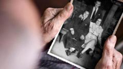Mãos de pessoa idosa segurando foto antiga de família em preto e branco