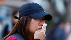 Bir kadın, ölümcül yangının ardından gözyaşlarını siliyor.