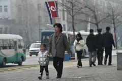Personas y vehículos transitan por una calle de Pyongyang.