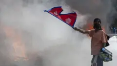 मङ्गलवार सिंहदरबारमा आगजनी भएपछि नजिकै नेपालको झण्डा बोकेर उभिएका एक युवक