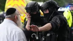 সাদা পোশাক পরা একজন ইহুদি ব্যক্তির সঙ্গে কথা বলছেন কালো ইউনিফর্ম পরা পুলিশের দুই সদস্য