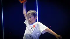 ကိုယ်ခန္ဓာကြံ့ခိုင်မှုအပိုင်း စမ်းသပ်မှု ပြီးဆုံးတဲ့နောက် လေထဲမှာ လက်ကို ဝေ့ယမ်းပြနေတဲ့ ရှေ့တူရှု လူငယ်ကောင်လေးတစ်ဦးဓာတ်ပုံ 