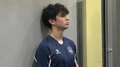 スポーツTシャツを着た若い男、暗い巻き毛の髪