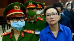 Чионг Мі Лан сидить у залі суду поруч із чоловіком у військовій формі