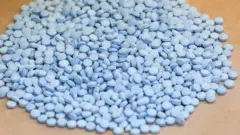 Grande pilha de pequenas pílulas azuis