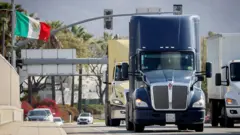 Caminhões carregados passam por uma ponte na fronteira entre o México e os Estados Unidos