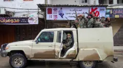 Tabka'da Suriye ordu güçleri beyaz bir kamyonetin üzerinde ellerinde silahlarla görülüyor