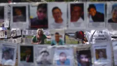 Familiares de desaparecidos, ao lado de suas fotos no México