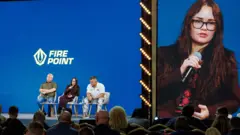 Два чоловіки і жінка сидять на сцені