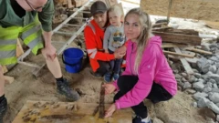 Família ao lado de espada encontrada enterrada no quintal