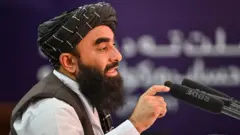 ذبیح‌الله مجاهد، سخنگوی حکومت طالبان هنگام صحبت در یک نشست خبری