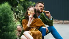 Man and woman eating meat