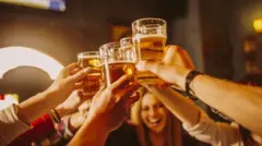 Pessoas brindam com copos de cerveja