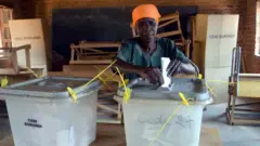 Umutamakazi ariko arashira urupapuro rw'itora mu gasandugu k'amatora, Bujumbura, 29 Ruheshi 2015