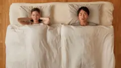 Seorang perempuan terganggu tidurnya karena pasangannya mendengkur