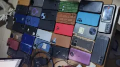 Un gros plan de différentes marques de téléphones et de chargeurs placés sur une table 