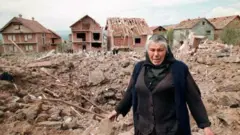 Une femme âgée pleure à côté des décombres de maisons détruites, le 28 avril 1999 à Surdulica, à quelque 250 km au sud de Belgrade. 