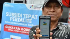 Warga menunjukkan bukti pendaftaran subsidi tepat Pertalite di SPBU kawasan Seminyak, Badung, Bali, Rabu (28/8/2024). 