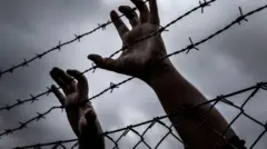 Foto wey dey show pesin hands for barbwire wey look like say e wan try to escape