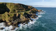 왼편에 산과 트레킹 코스가 있으며 오른편에 바다가 있다