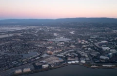 Vista aérea do Vale do Silício ao entardecer, com parte da ponte San Mateo/Hayward visível, bem como Foster City, incluindo as sedes da Gilead Sciences, Visa e Conversica na Califórnia.