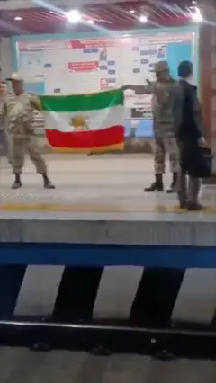 دو مرد با لباس نظامی و پرچم شیر و خورشید در متروی تهران