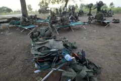 Des matériels militaires et quelques éléments des forces armées béninoises assis sous un arbre.