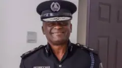 Tunji Disu, acting Inspector-General of police wear black police uniform