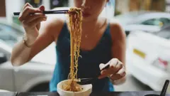 Жінка їсть макарони