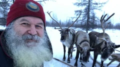 Бородатый мужчина в бордовой шапочке на фоне оленей