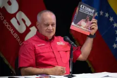 Diosdado Cabello vestido con camisa de color rojo sostiene un ejemplar de la revista 4F en la mano, con la cara de Maduro en la portada.
