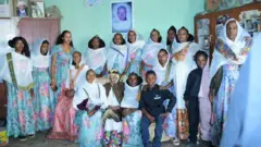 ተወሊደን ኣብ ዝዓበያሉ ማእከል ዓዲ ድግሳ፡ ካብ ዓዲ ሽም ምሕረት፡ ናብ ዓዲ ሽም ጴጥሮስ (ጴጥሮሽ) እንዳ ሃብተ ፍታው ኣትየን 12 ከብደን ዝወለዳ ኣደይ ሓጉሽ ካብ እግሪ በዓል ቤተን ከይበዀራ ቆፈአን ዘህጠራ ጻዕራም ሓረስታይ ነይረን