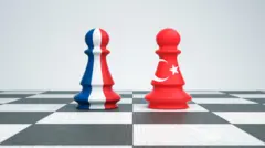 Satranç tahtasında üzerlerinde Fransa ve Türkiye bayrakları olan iki piyon karşı karşıya geliyor