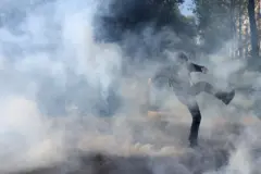 Um manifestante corre em meio à gás lacrimogêneo durante confrontos com a polícia francesa.