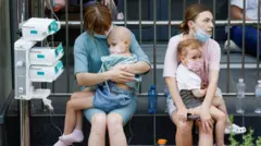 Niños y enfermeras esperando frente al hospital infantil Ohmatdyt 